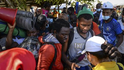 Des migrants haïtiens tentent d'embarquer sur un bâteau pour le Panama, le 13 septembre 2021, à Necocli (Colombie). (VANESSA JIMENEZ G. / ANADOLU AGENCY / AFP)