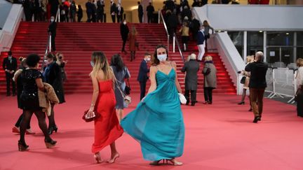 Des invités masqués arrivent au Palais des festivals à Cannes pour une mini-cérémonie confinée le 7 octobre 2020. (VALERY HACHE / AFP)