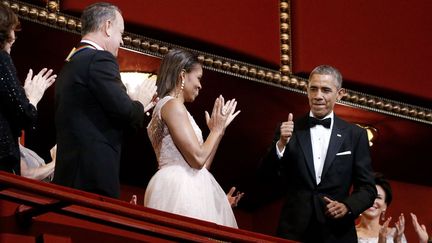 Le pr&eacute;sident am&eacute;ricain Barack Obama&nbsp;(D) f&eacute;licite la Premi&egrave;re Dame Michelle Obama (C) pour sa tenue &agrave; l'occasion d'une soir&eacute;e au Kennedy Center &agrave; Washington (Etats-Unis), le 7 d&eacute;cembre 2014. (JONATHAN ERNST / REUTERS)