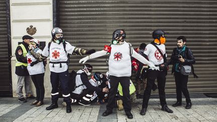 Des street-medics s'occupent d'un blessé lors d'une manifestation des "gilets jaune" à Paris, le 16 mars 2019. (YANN CASTANIER / HANS LUCAS / AFP)