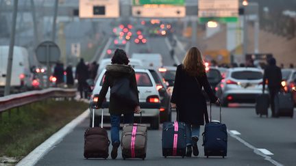 Des voyageurs se rendent à Orly à pieds lors d'un blocage des VTC, le 17 décembre 2016. (CHRISTOPHE ARCHAMBAULT / AFP)