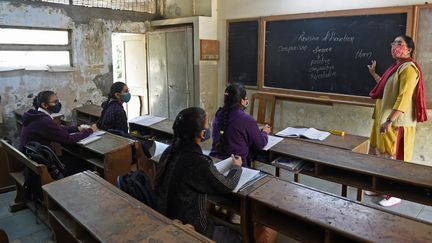 Des élèves dans leur classe après la réouverture des écoles près de neuf mois après la propagation du Covid-19 à Ahmedabad (11 janvier 2021). (SAM PANTHAKY / AFP)