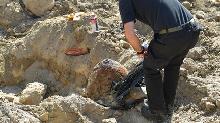 Un démineur se penche sur une bombe de la Deuxième Guerre mondiale, découverte lors de travaux à Ludwigshafen (Allemagne) et déminée le 26 août 2018. (UWE ANSPACH / AFP)