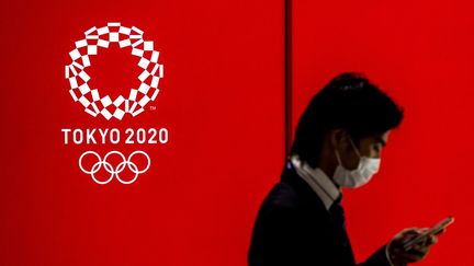 Un homme devant le logo des JO de Tokyo 2020, le 15 juillet 2020. (BEHROUZ MEHRI / AFP)