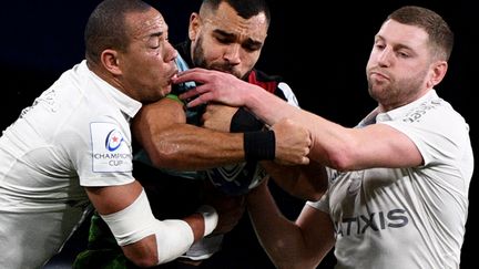 Les Franciliens Gaël Fickou et Finn Russel aux prises avec l'Anglais Joe Marchant, lors de la rencontre de Champions Cup entre le Racing 92 et les Harlequins, le 15 janvier 2023, à Nanterre. (CHRISTOPHE ARCHAMBAULT / AFP)