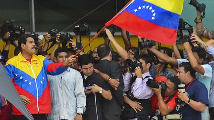 Le pr&eacute;sident v&eacute;n&eacute;zu&eacute;lien par int&eacute;rim, Nicolas Maduro, agite le drapeau national devant les photographes &agrave; l'occasion de son d&eacute;p&ocirc;t de candidature pour la future &eacute;lection pr&eacute;sidentielle, Caracas (Venezuela), le 11 mars 2013. (LUIS ACOSTA / AFP)