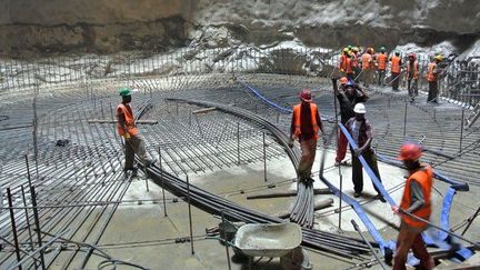 Commencé en 2006, le plus haut barrage d'Afrique devrait être terminé en 2014. Aujourd'hui, 4.500 ouvriers travaillent à la construction de l'édifice, achevé pour moitié. Turbines électriques, unités de cimenterie, canaux d'acheminement du ciment et tunnels pour la circulation de l'eau… sont en place.

L'eau pourra commencer à être retenue sur une surface de 210 km², dès 2013. (AFP PHOTO / JENNY VAUGHAN)