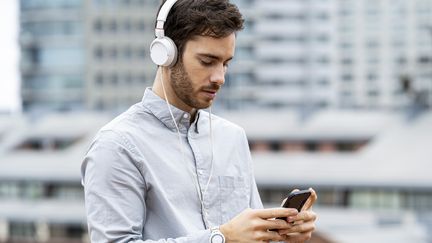 Un homme écoute de la musique sur son smartphone. (FREDERIC CIROU / MAXPPP)