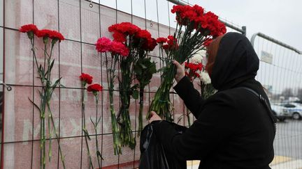 Des fleurs en mémoire des victimes devant la salle de concert de Krasnogorsk (Russie), le 24 mars 2023. (STRINGER / AFP)