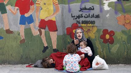 Une r&eacute;fugi&eacute;e syrienne fait la manche avec des enfants dans une rue de Beyrouth (Liban), le 16 f&eacute;vrier 2015. (JAMAL SAIDI / REUTERS)