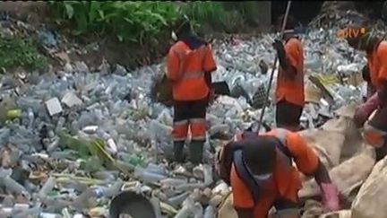 Ramassage de bouteilles en plastique dans un fossé à Douala. (AITV)