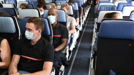 Des pompiers et du personnel médical dans un vol Air France à destination de la Guadeloupe, à l'aéroport d'Orly, le 20 août 2021. (STEPHANE DE SAKUTIN / AFP)