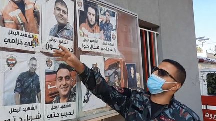 Un pompier de la caserne proche du port de Beyrouth (Liban) montre les portraits des dix hommes qui ont péri dans l'explosion du 4 août 2020 (CHRISTIAN CHESNOT / RADIO FRANCE)