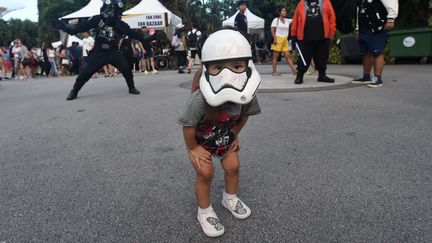 Un enfant porte un casque de Stormtrooper, personnage de Star Wars, lors du "Star Wars day", le 4 mai 2017 à Singapour.&nbsp; (ROSLAN RAHMAN / AFP)