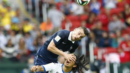 Le Fran&ccedil;ais Mathieu Debuchy &agrave; la lutte pour le ballon avec Roger Espinoza du Honduras lors d'un match de Coupe du Monde opposant ces deux &eacute;quipes du groupe E &agrave; Porto Alegre (Br&eacute;sil), le 15 juin 2014. (MURAD SEZER / REUTERS)