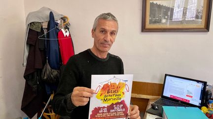 Fathi Bouaroua, responsable d’Emmaüs Pointe-Rouge à Marseille, montre les affiches à l'origine du litige avec la mairie, le 5 décembre 2019. (DAVID AUSSILLOU / RADIO FRANCE)