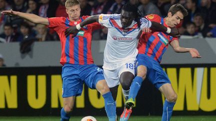 Bafetimbi Gomis (Lyon) tente de passer entre deux défenseurs de Plzen (MICHAL CIZEK / AFP)