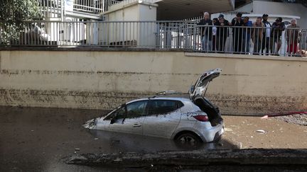 Des Cannois regardent avec int&eacute;r&ecirc;t, dimanche 4 octobre, un v&eacute;hicule abandonn&eacute; la veille &agrave; l'entr&eacute;e d'un tunnel. ( ERIC GAILLARD / REUTERS)