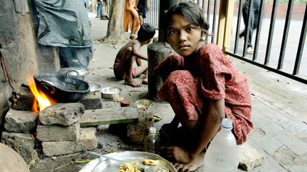 Une enfant se pr&eacute;pare un repas &agrave; Calcutta (Inde), en 2006. (DESHAKALYAN CHOWDHURY / AFP)