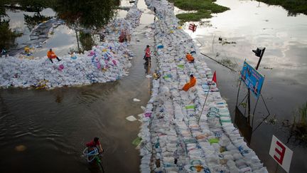 Les digues de sacs de sable mont&eacute;es &agrave; la h&acirc;te par les habitants et les secours ne suffiront pas &agrave; contenir la masse d'eau qui se rapproche chaque jour un peu plus de m&eacute;galopole de 12 millions d'habitants. (DANIEL BEREHULAK / GETTY IMAGES)