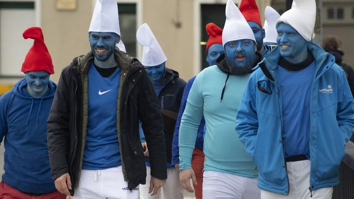 Des personnes déguisées en Grand Schtroumpf et en Schtroumpfs marchent alors qu'elles participent à un rassemblement record de Schtroumpfs à Landerneau, dans l'ouest de la France, le 25 mars 2023. (FRED TANNEAU / AFP)