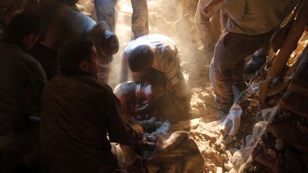 Les premiers secours s'organisent. De nombreuses lignes t&eacute;l&eacute;phoniques et l'&eacute;lectricit&eacute; sont coup&eacute;es. Dans la nuit, des habitants du village de Sourmah tentent d'extraire une femme des d&eacute;combres. (FARSHID TIGHEHSAZ / ISNA / AFP)