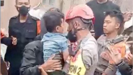 Un enfant est retrouvé vivant le 24 novembre 2022 dans les décombres après le séisme survenu lundi sur l'île de Java (Indonésie). (BASARNAS / HANDOUT / ANADOLU AGENCY / AFP)