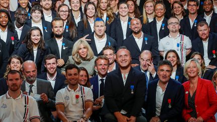 Le président de la république Emmanuel Macron, et son épouse Brigitte, posent avec les médaillés français des Jeux olympiques et paralympiques de Tokyo, reçus à l'Elysée le 13 septembre 2021. (BENOIT TESSIER / AFP)