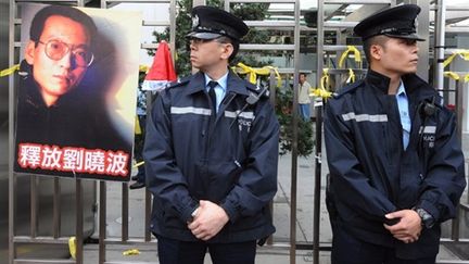 Hong Kong, le 25 décembre 2009: derrière les policiers, le dissident chinois Liu Xiaobo condamné à 11 ans de prison. (AFP/MIKE CLARKE)