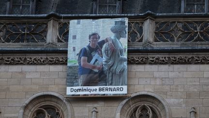 A portrait of Dominique Bernard on the facade of Arras town hall, October 19, 2023 during a tribute. (FRANCOIS LO PRESTI / AFP)