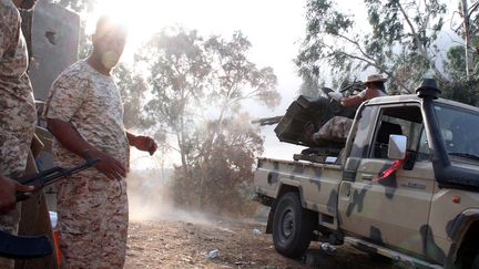 Un milicien utilise une mitrailleuse, le 17 ao&ucirc;t 2014 non loin de l'a&eacute;roport de Tripolie (Libye). (MAHMUD TURKIA / AFP)