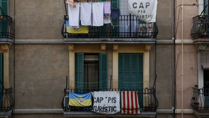 Des bannières "Ce ne sont pas des appartements pour les touristes" sont accrochées à un balcon d'un immeuble, dans le quartier de Barceloneta, à Barcelone, le 24 octobre 2016. (PAU BARRENA / AFP)