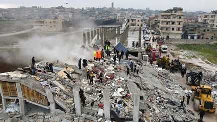 Des habitants de Sarmada recherchent des survivants dans les décombres des bâtiments effondrés à la suite d'un tremblement de terre qui a touché la ville située au nord-ouest de la Syrie, le 6 février 2023. (MUHAMMAD HAJ KADOUR / AFP)