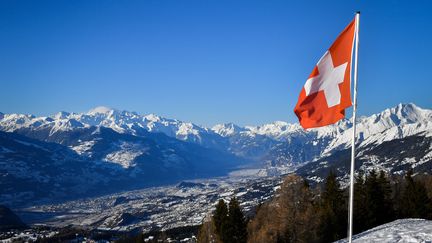 Le drapeau suisse dans les Alpes, en mars 2018.&nbsp; (FABRICE COFFRINI / AFP)