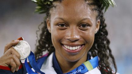 Pour ses premiers Jeux olympiques, Allyson Felix s'offre l'argent sur le 200 mètres à Athènes, le 25 août 2004. Par la même occasion, la sprinteuse de 18 ans améliore le record du monde de la distance chez les juniors (22"18). Le précédent datait de 1980. Cette marque&nbsp;tiendra plus de quinze ans.&nbsp; (TOSHIFUMI KITAMURA / AFP)