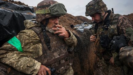 Des soldats ukrainiens se tiennent dans une tranchée près de Bakhmout, dans l'est du pays, le 13 avril 2023. (ANATOLII STEPANOV / AFP)