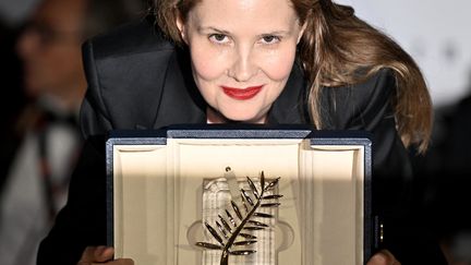 La réalisatrice française Justine Triet pose après avoir remporté la Palme d'Or pour le film "Anatomie d'une Chute" lors de la cérémonie de clôture du 76e Festival de Cannes le 27 mai 2023 (MUSTAFA YALCIN / ANADOLU AGENCY)