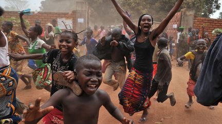 Des enfants courent derri&egrave;re le bus de la nouvelle pr&eacute;sidente centrafricaine Catherine Samba-Panza &agrave; l'issue de sa visite dans un camp de r&eacute;fugi&eacute;s &agrave; Bangui (Centrafrique), le 1er f&eacute;vrier 2014. (ISSOUF SANOGO / AFP)