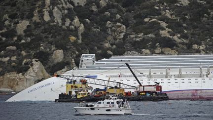 Une &eacute;quipe technique s'affaire autour du "Costa Concordia", &eacute;chou&eacute; pr&egrave;s de l'&icirc;le toscane du Giglio, le 27 janvier 2012. (FILIPPO MONTEFORTE / AFP)