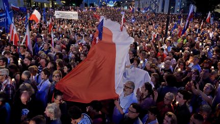 Des manifestants brandissent des bougies et des drapeaux polonais et européens, le 20 juillet 2017, à Varsovie (Pologne). (ADAM CHELSTOWSKI / AFP)