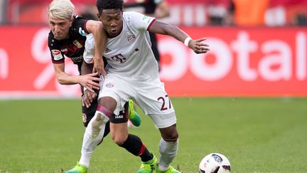 Le joueur du Bayern, David Alaba (en maillot blanc), au duel avec Kevin Kampl, du Bayer Leverkusen (MARIUS BECKER / DPA)