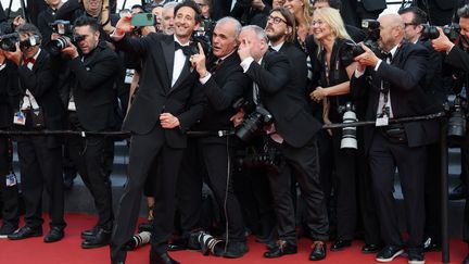 Adrien Brody n'a pas quitté son téléphone pour prendre des selfies sur le tapis rouge, malgré l'interdiction du Festival. Il prend cette fois-ci la pose avec des photographes amusés. (VITTORIO ZUNINO CELOTTO / GETTY IMAGES EUROPE)