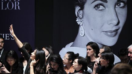 Des interm&eacute;diaires d'acheteurs se pressent &agrave; la vente aux ench&egrave;res des bijoux d'Elizabeth Taylor &agrave; New York (Etats-Unis), mardi 13 d&eacute;cembre au soir. (REUTERS / CARLO ALLEGRI)