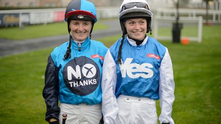 Deux femmes-jockeys, l'une repr&eacute;sentant le "oui" et l'autre le "non" se pr&eacute;parent &agrave; participer &agrave; la "course du r&eacute;f&eacute;rendum" &agrave; Edimbourgh (Ecosse), le 15 septembre 2014. (LEON NEAL / AFP)