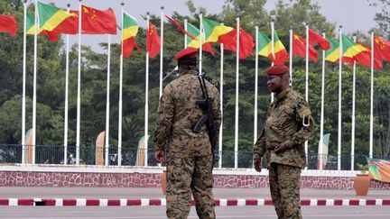 Des militaires montent la garde devant une rangée de drapeaux congolais et chinois au Palais des Congrès, le 29 mars 2013 à Brazzaville.    (JUNIOR D. KANNAH / AFP)