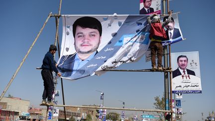 Des hommes accrochent des affiches électorales à Kaboul (Afghanistan), le 2 octobre 2018.&nbsp; (WAKIL KOHSAR / AFP)