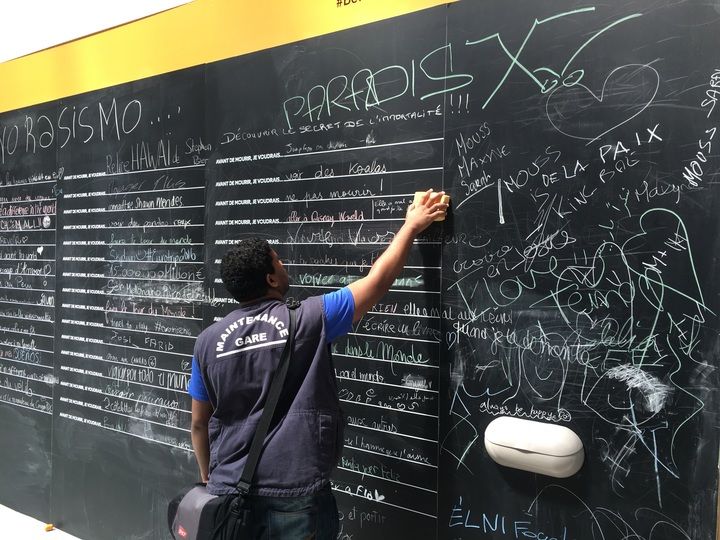 Un agent de maintenance efface les messages indésirables à l'aide d'une éponge, mardi 9 août 2016, gare de Lyon à Paris. (F. MAGNENOU / FRANCETV INFO)