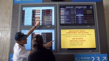 Devant le panneau des vols, annonce de la grève d'Air Algérie, à l'aéroport d'Orly, le 14 juillet 2011 (AFP. T.Samson)