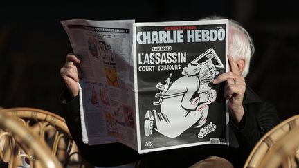 Un homme lit "Charlie Hebdo" à la terrasse d'un café, le 6 janvier 2016, à Nice (Alpes-Maritimes). (ERIC GAILLARD / REUTERS)