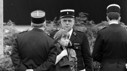 Murielle Bolle, alors âgée de 15 ans, entourée de policiers à Epinal (Vosges), le 5 novembre 1984. (JEAN-CLAUDE DELMAS / AFP)